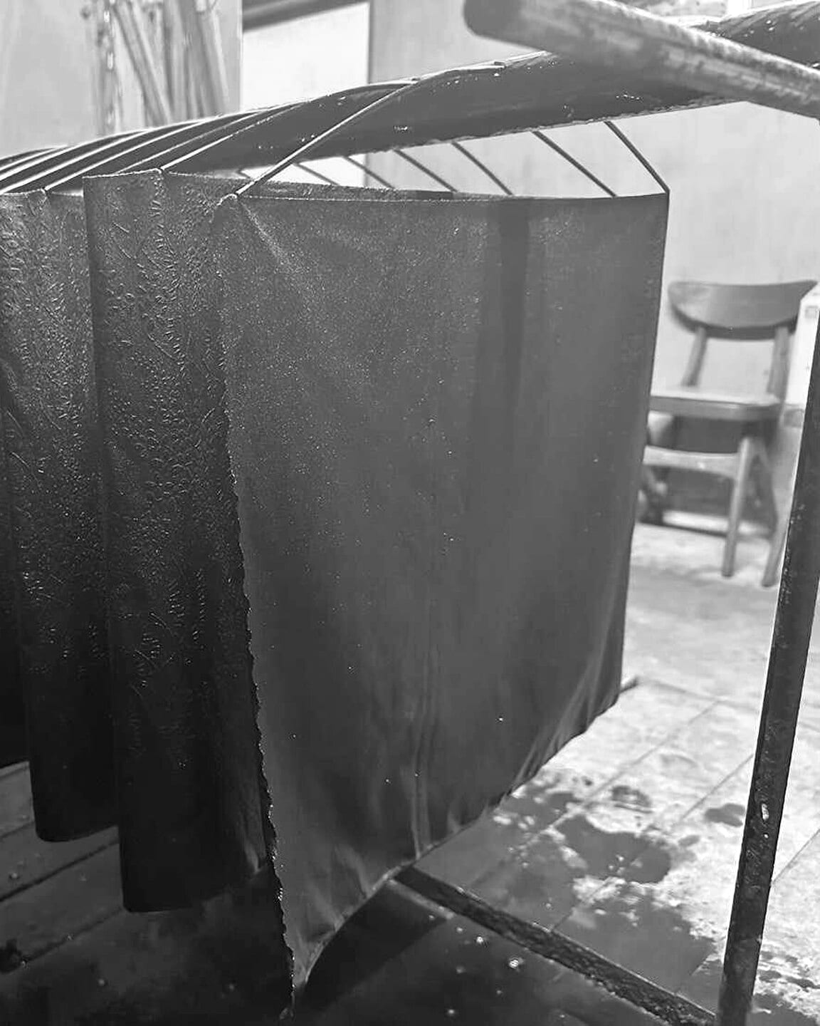 Freshly indigo-dyed cloth hanging over a dye vat